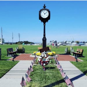 A memorial clock stands in the center of a park